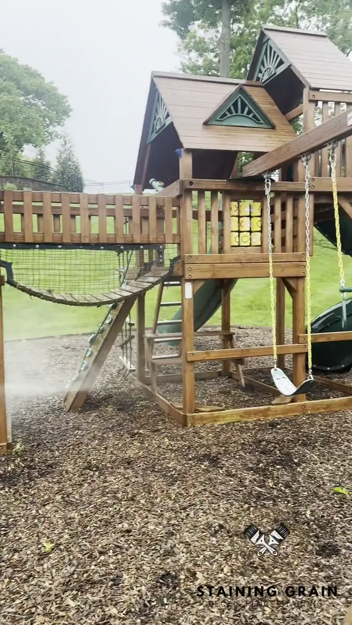 Staining Grain crew softwashing a wood play structure